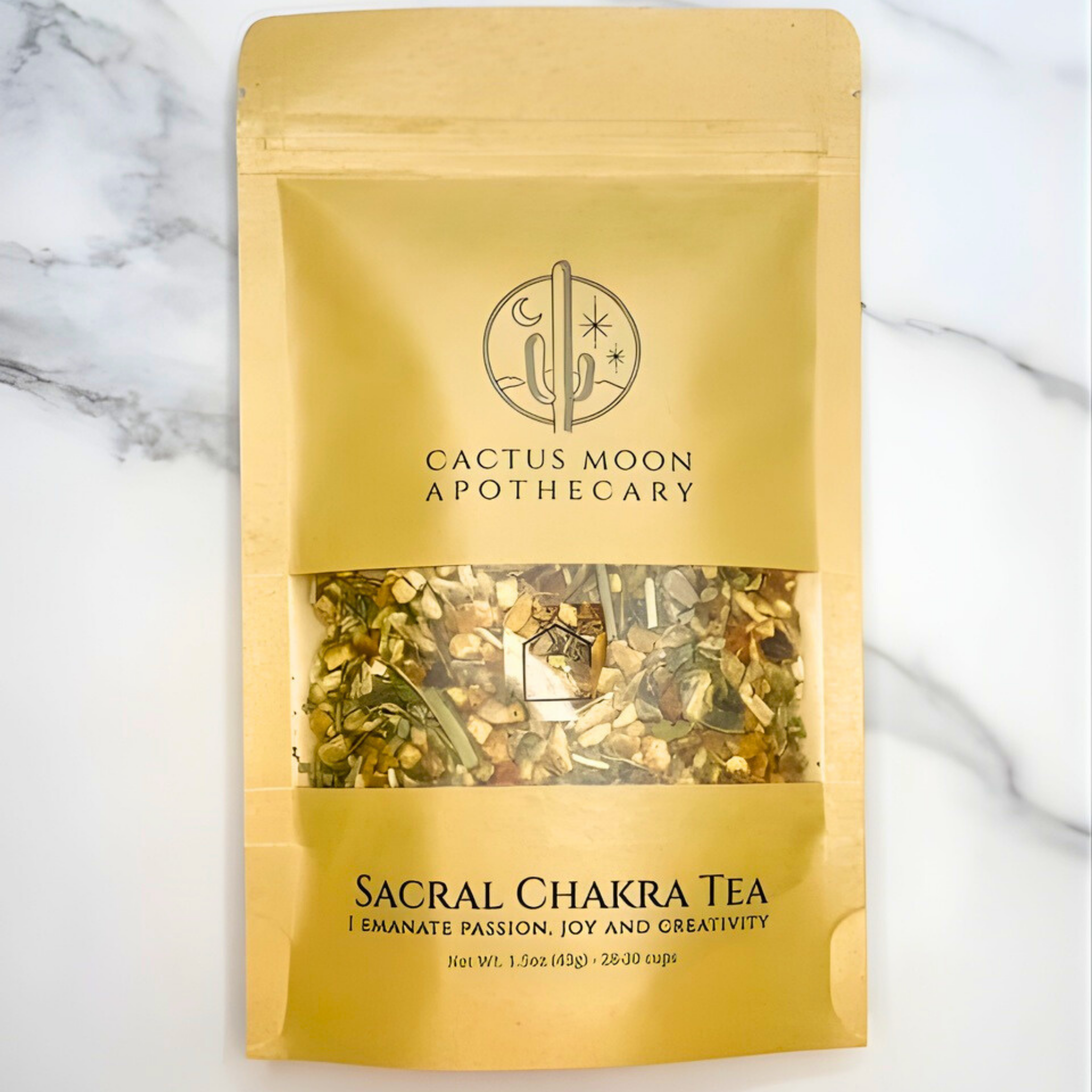 Gold packaging of Cactus Moon Apothecary Sacral Chakra Tea on a marble background