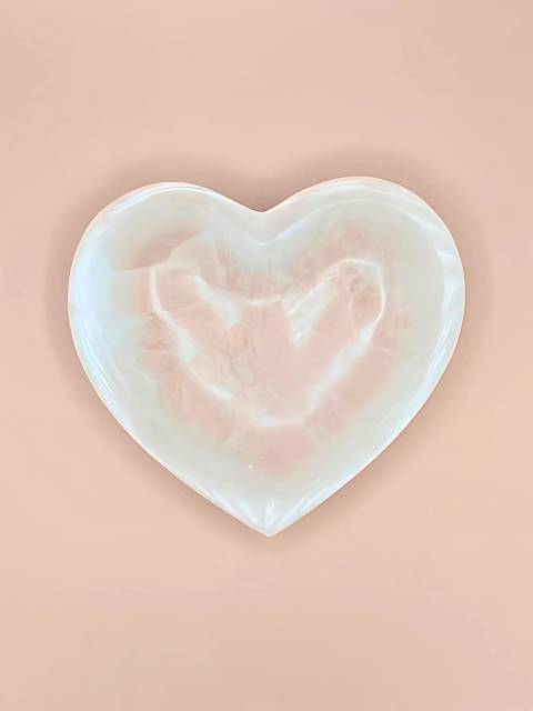 Heart-shaped seashell on a pink background