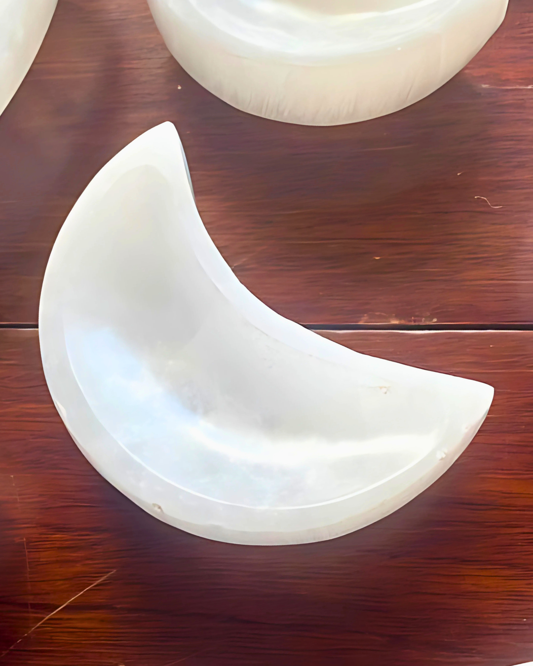 White crescent-shaped object on a wooden surface