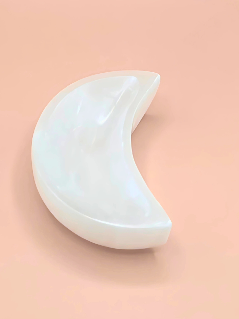 White crescent moon-shaped object on a pink background