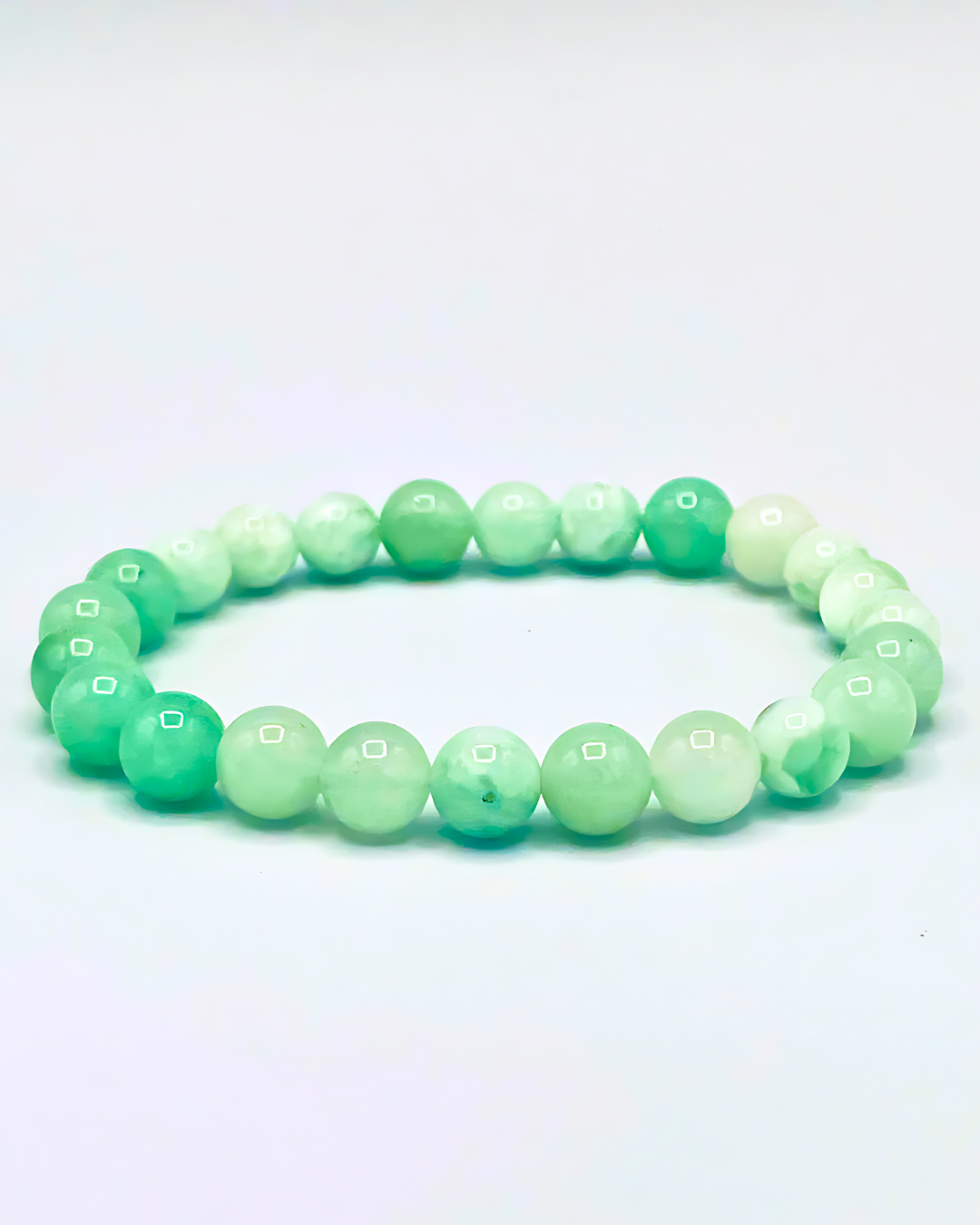 Green beaded bracelet on a light gray background