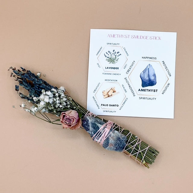 Amethyst smudge stick with dried flowers and a card on a beige background