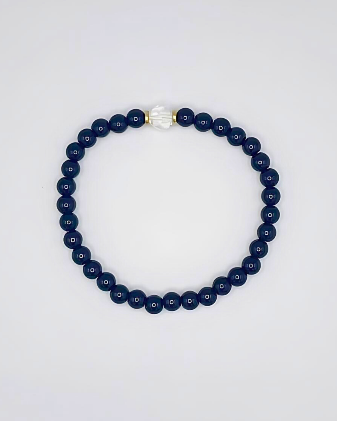 Navy blue beaded necklace on a light gray background