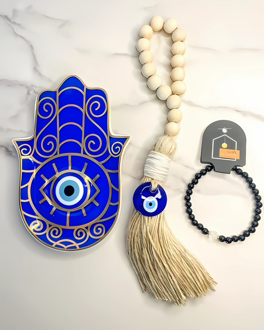 Blue Hamsa hand with evil eye, tassel, and bracelet on a marble background