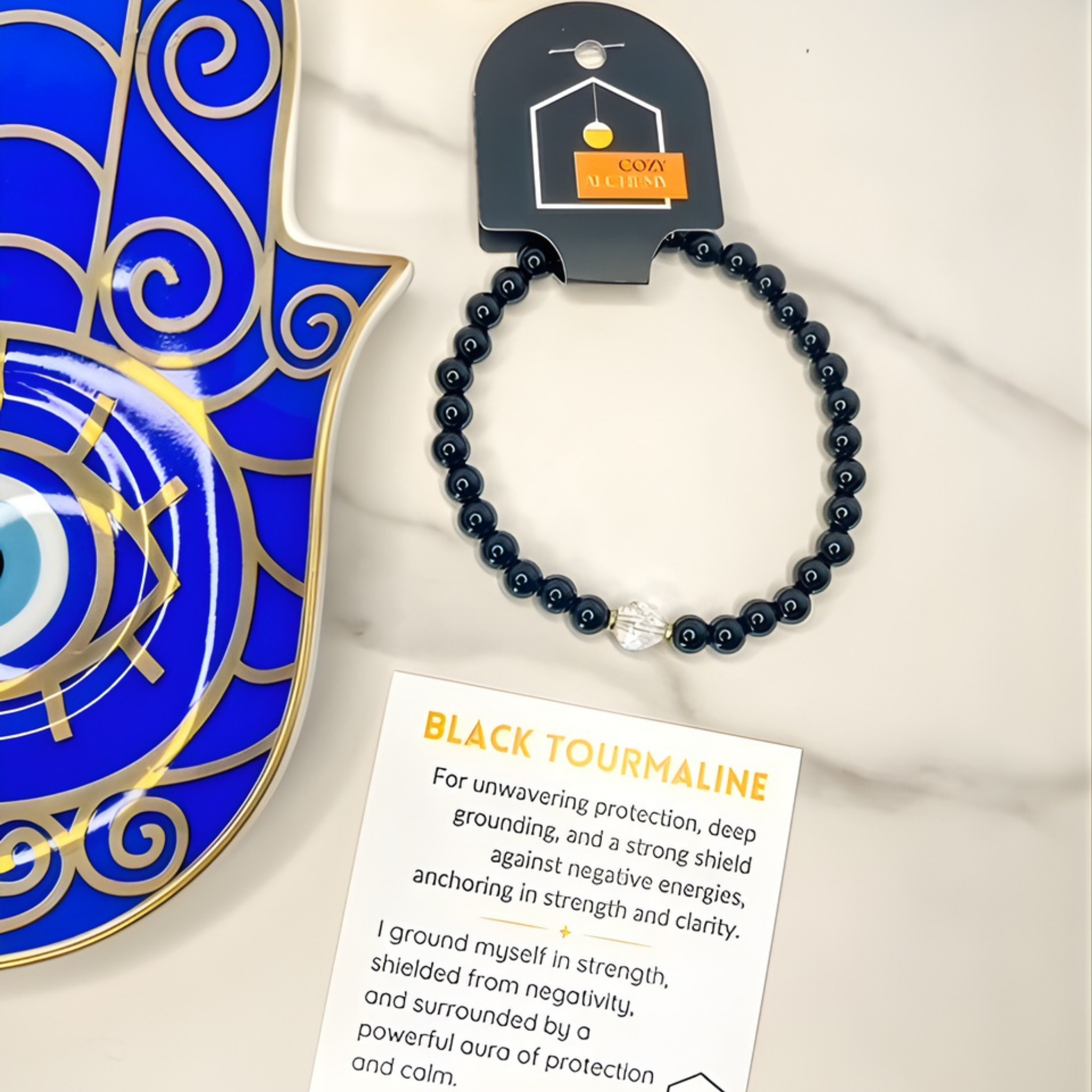 Black tourmaline bracelet on a card with an evil eye symbol and COVA branding.