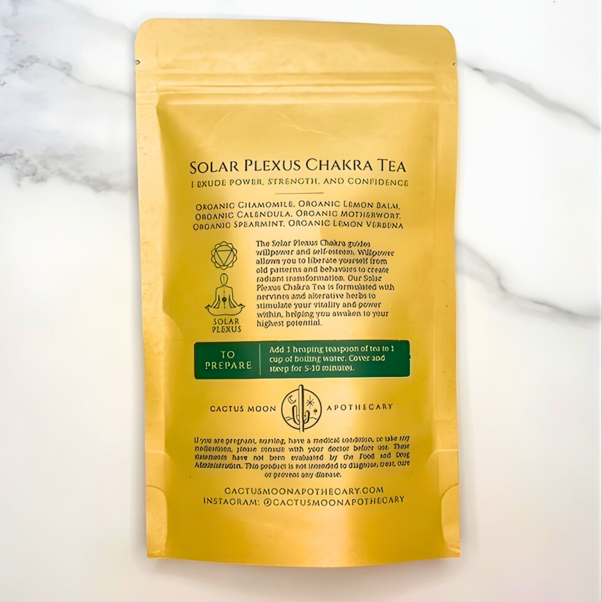 Yellow package of Solar Plexus Chakra Tea with text on a white marble background