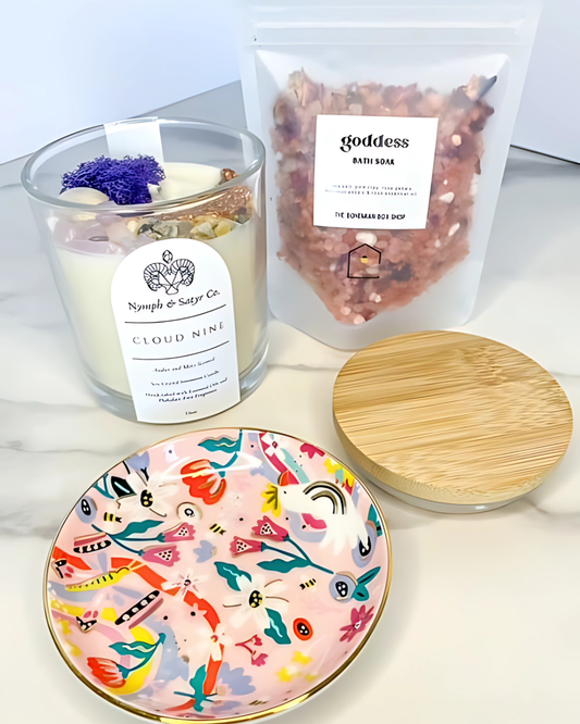 Candle, decorative plate, and bag of bath bombs on a white surface