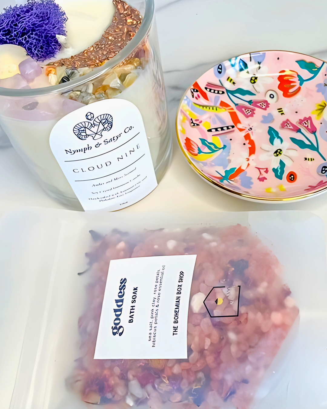 Candle labeled 'Cloud Nine' with a decorative plate and bath bomb packaging on a white surface.