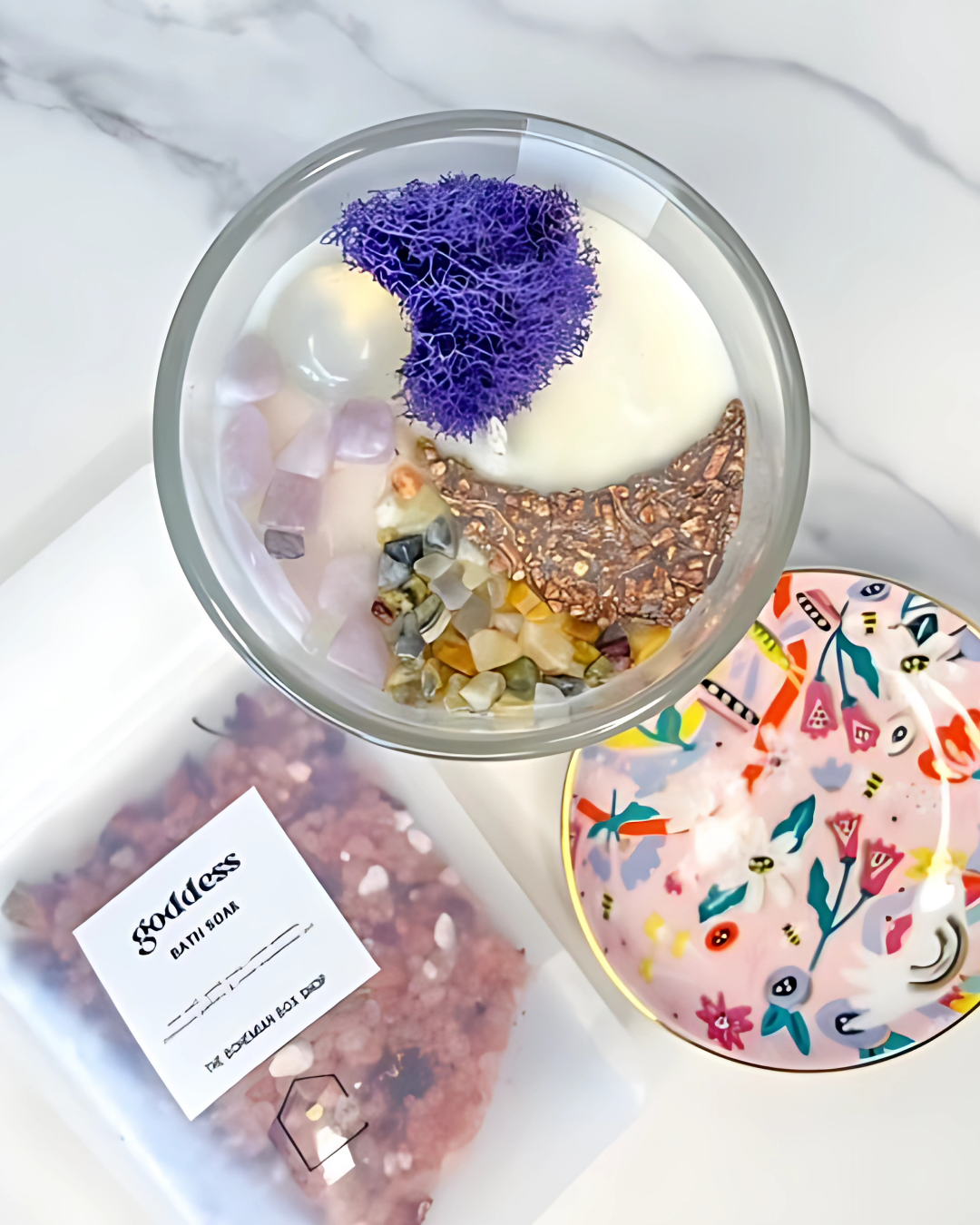 Bath bomb with decorative elements on a white surface, next to a Goldless bath bar and a colorful soap dish.