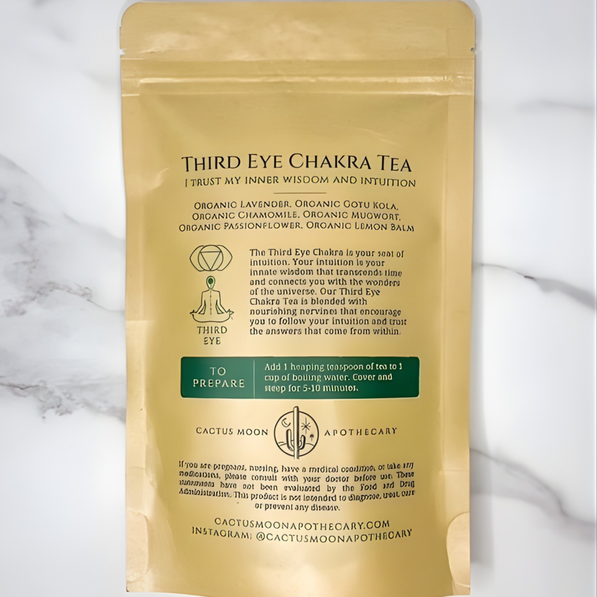 Gold packaging of Third Eye Chakra Tea with text on a marble background