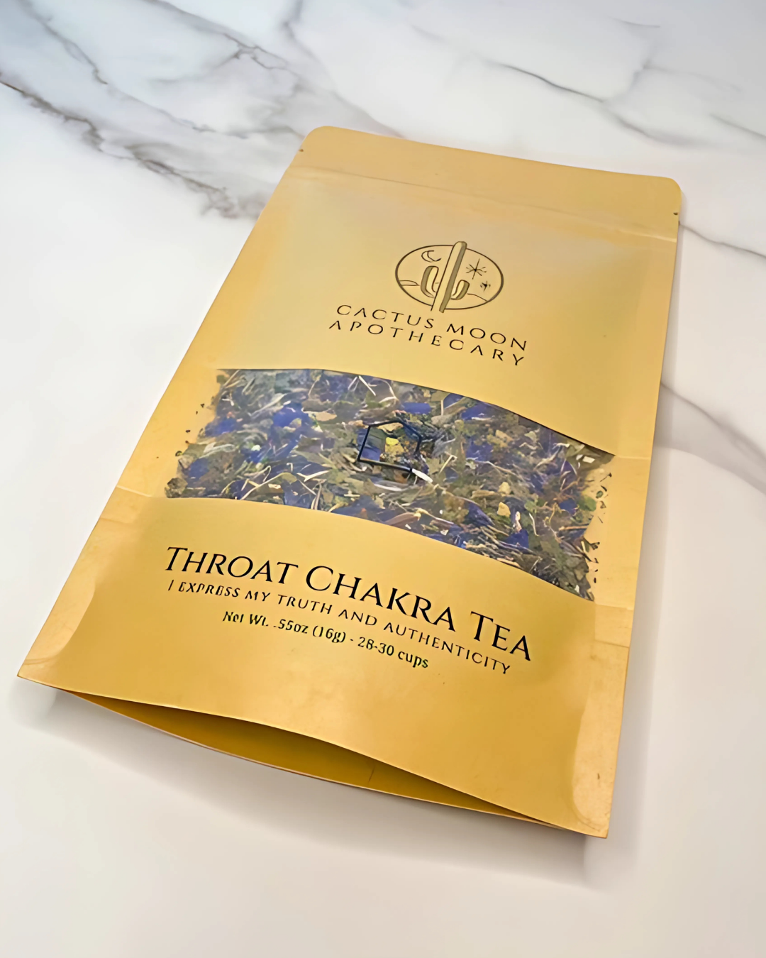 Gold packaging of Throat Chakra Tea from Cactus Moon Apothecary on a marble surface