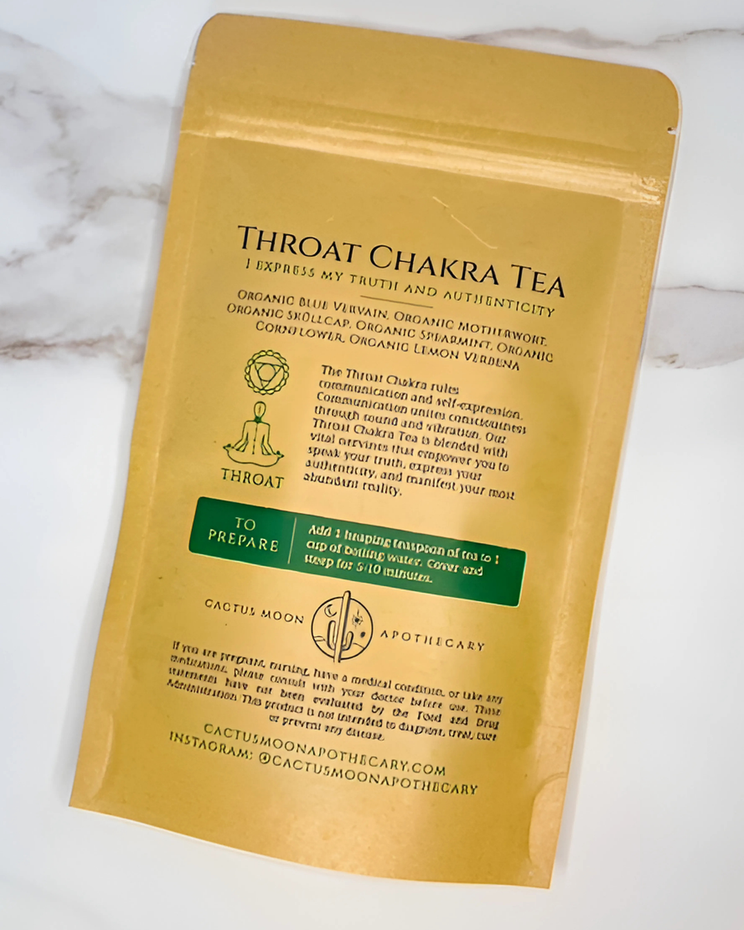 Yellow package of Throat Chakra Tea with text on a white marble background
