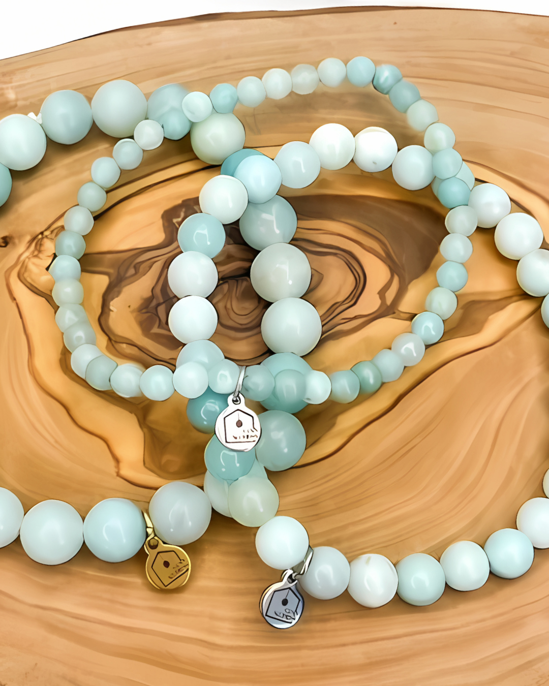 Set of beaded bracelets with charms on a wooden surface