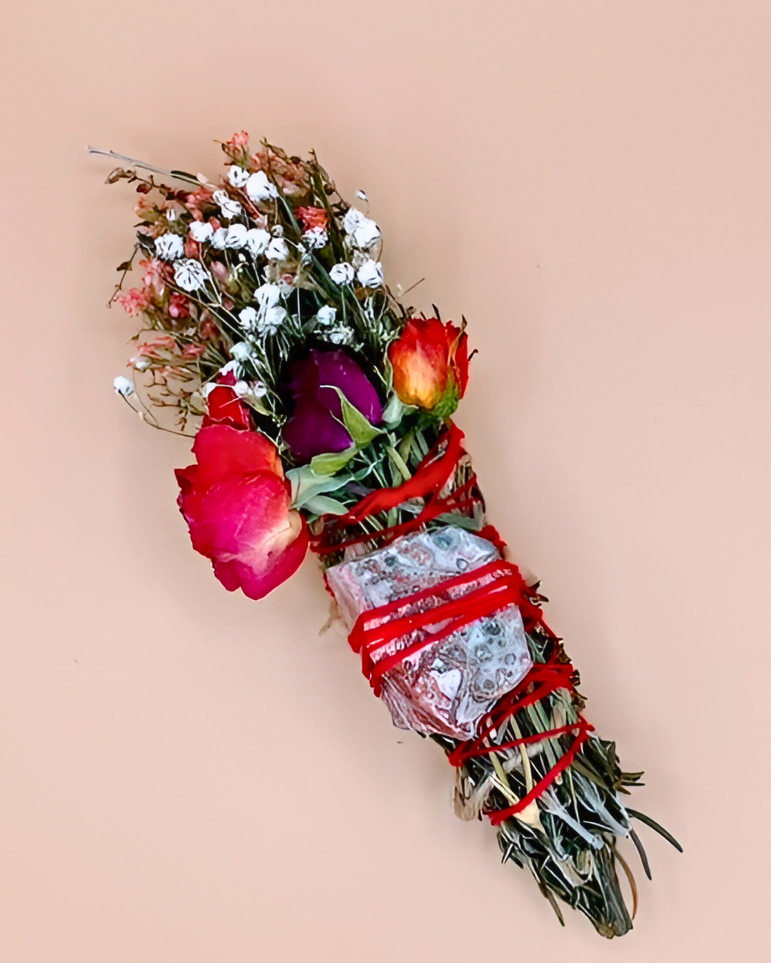 Bouquet of flowers with red ribbons and a small wrapped gift on a beige background