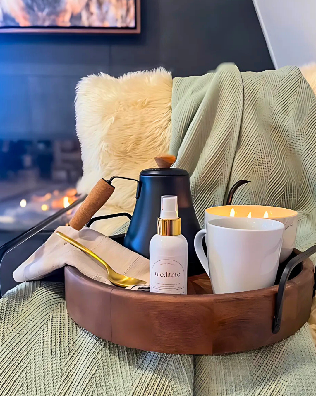 Tray with a mug, candle, and skincare product on a cozy couch.